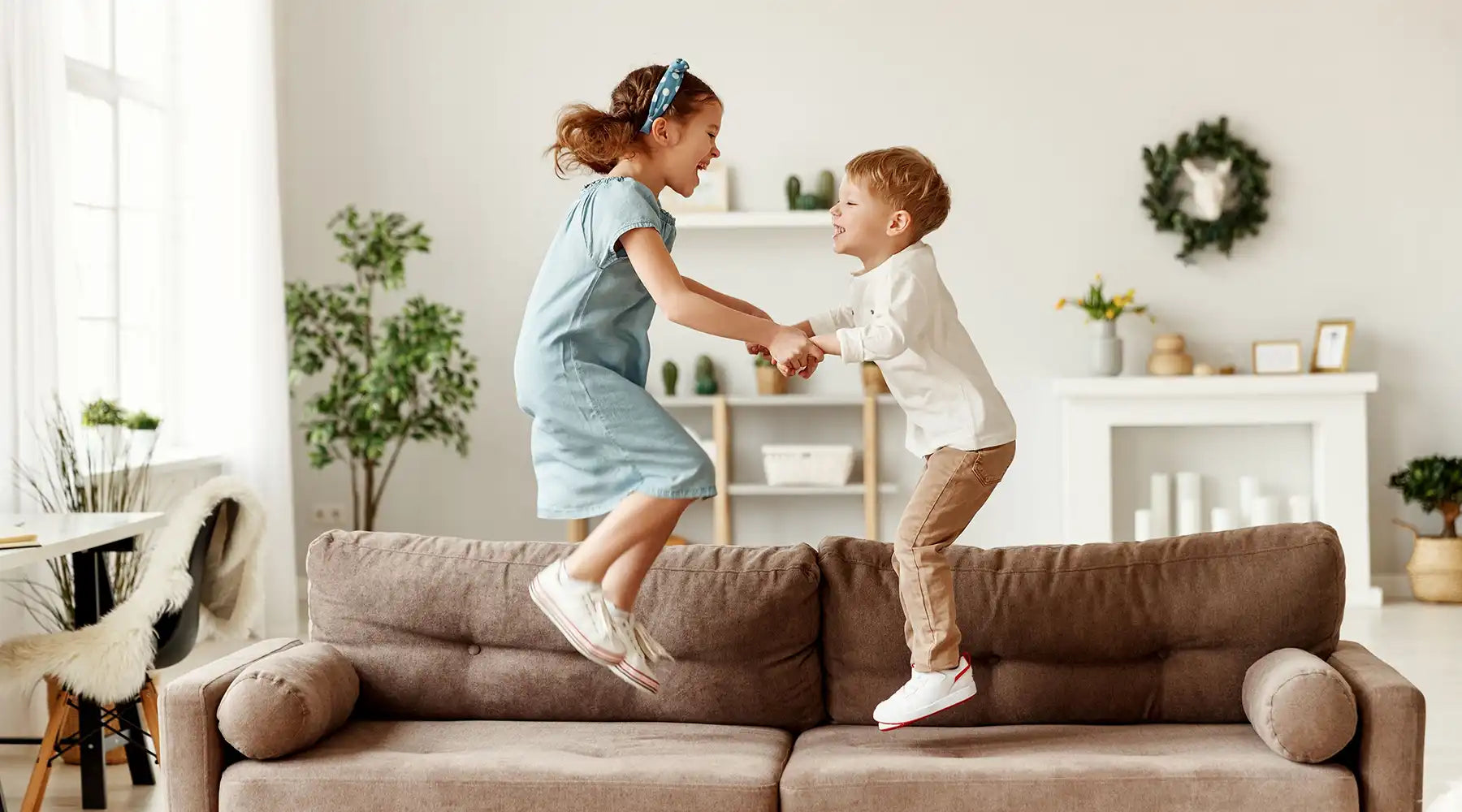 Two children playing on the sofa in the living room