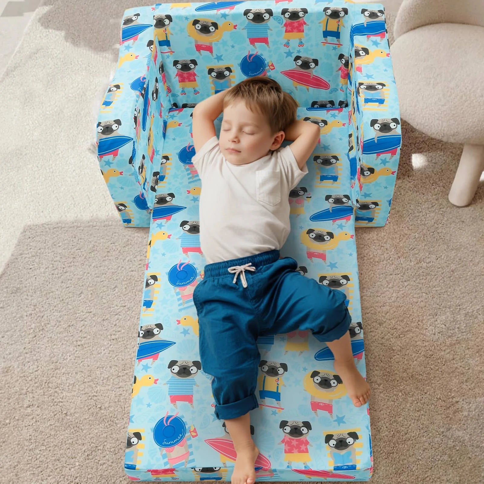 A little boy lying on an unfolded Glowsofa's Children's fold out sofa with Dog patterns